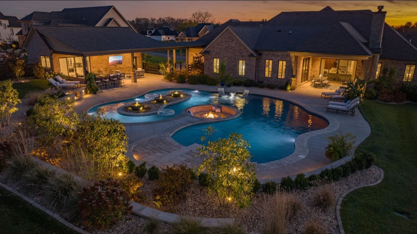 Pool terrace at dusk with a fire feature and covered seating