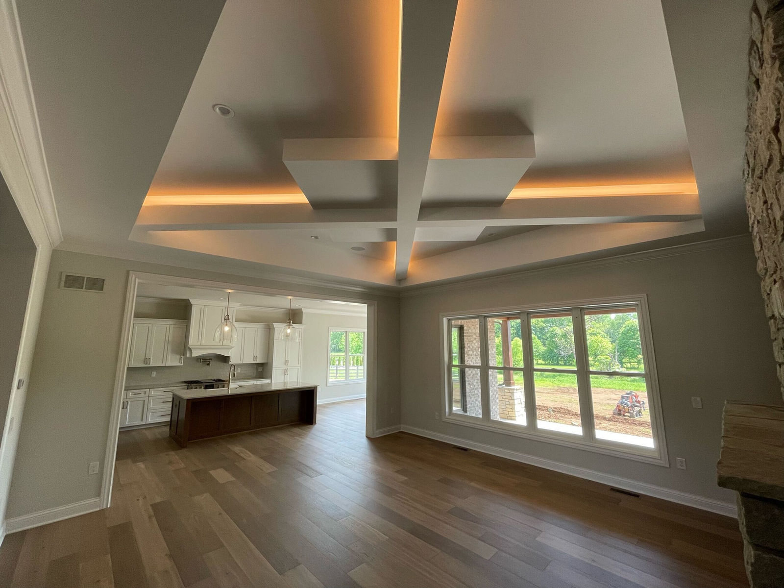 Living room with a coffered ceiling looking through to the kitchen