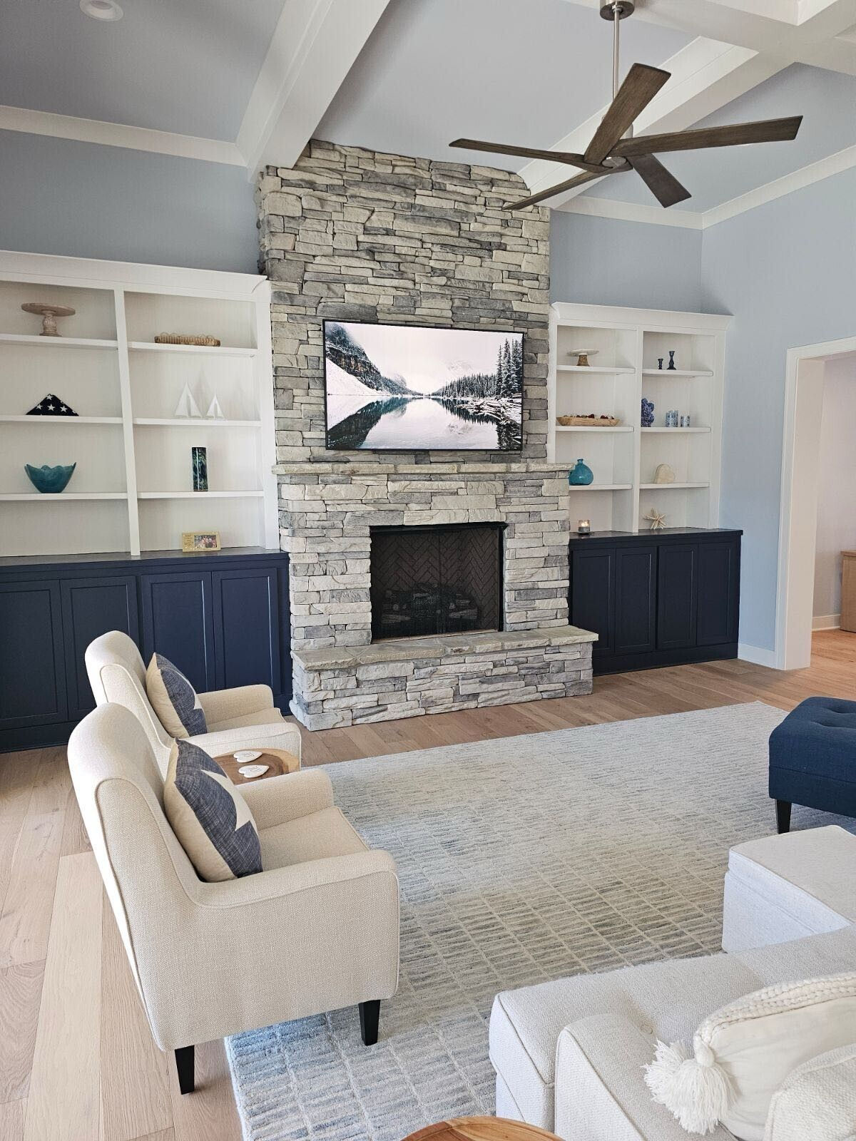 Living room with a stacked-stone fireplace and built-in cabinetry